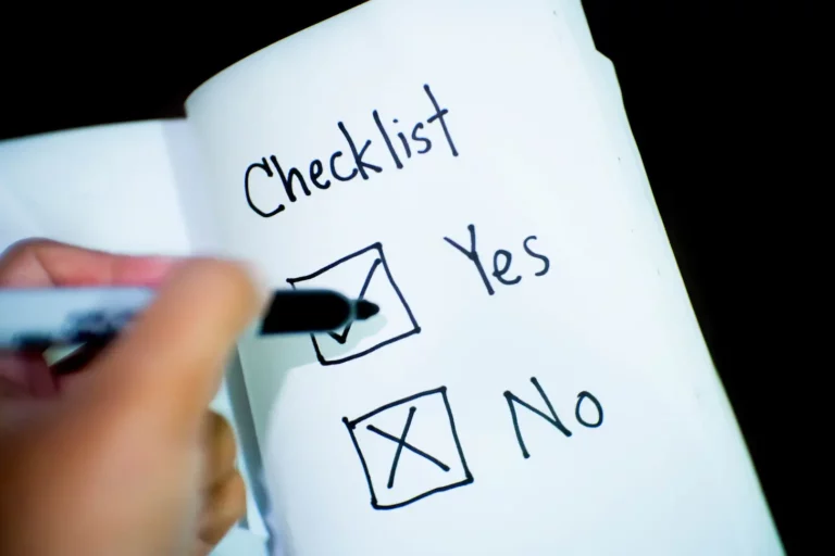 Hand mit einem Marker, der auf einer Papier-Checkliste „nein“ ankreuzt, wobei die Optionen „ja“ und „nein“ unter der Überschrift „Checkliste für Segelurlaub“ hervorgehoben sind.