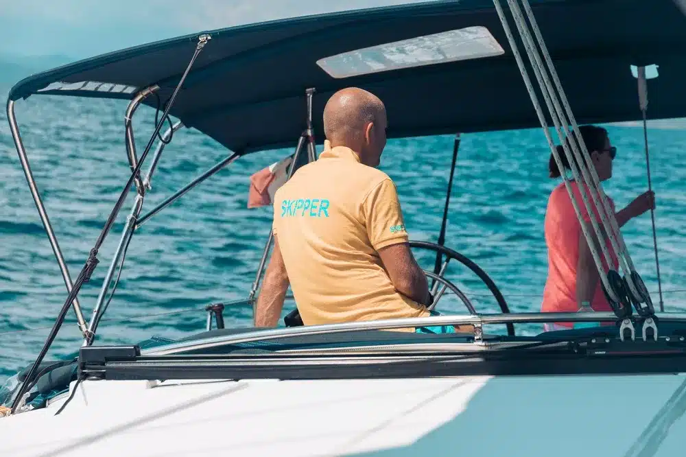Ein Mann sitzt auf einem Segelboot.