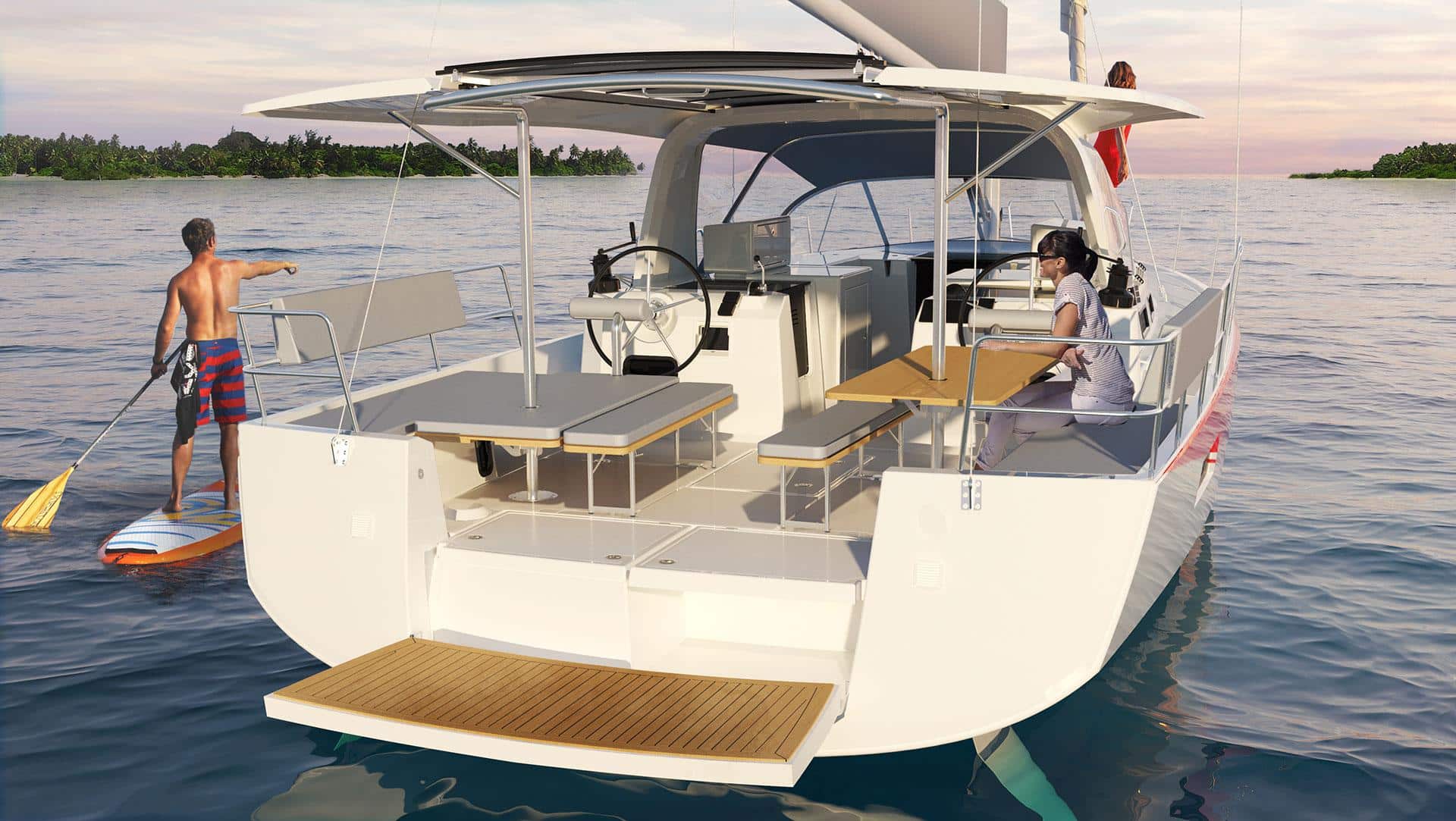 Eine moderne Segelyacht mit offenem Deck, Sitzbereichen und Steuerstand, schwimmt in der Nähe einer tropischen Küste. Zwei Personen gehen einer Aktivität nach: eine paddelt auf einem Brett und eine andere sitzt am Steuer.