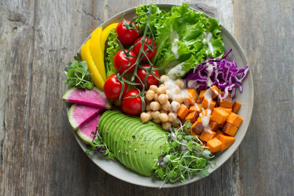 Eine farbenfrohe Salatschüssel mit Avocadoscheiben, Kirschtomaten, gelben Paprikastreifen, Kichererbsen, Süßkartoffelwürfeln, Rotkohl, Wassermelonen-Rettichscheiben, Blattgemüse und Microgreens mit einem Schuss Dressing. Genießen Sie es an Bord einer Segelyacht, während Sie Ihre Segelreise auf offener See genießen.