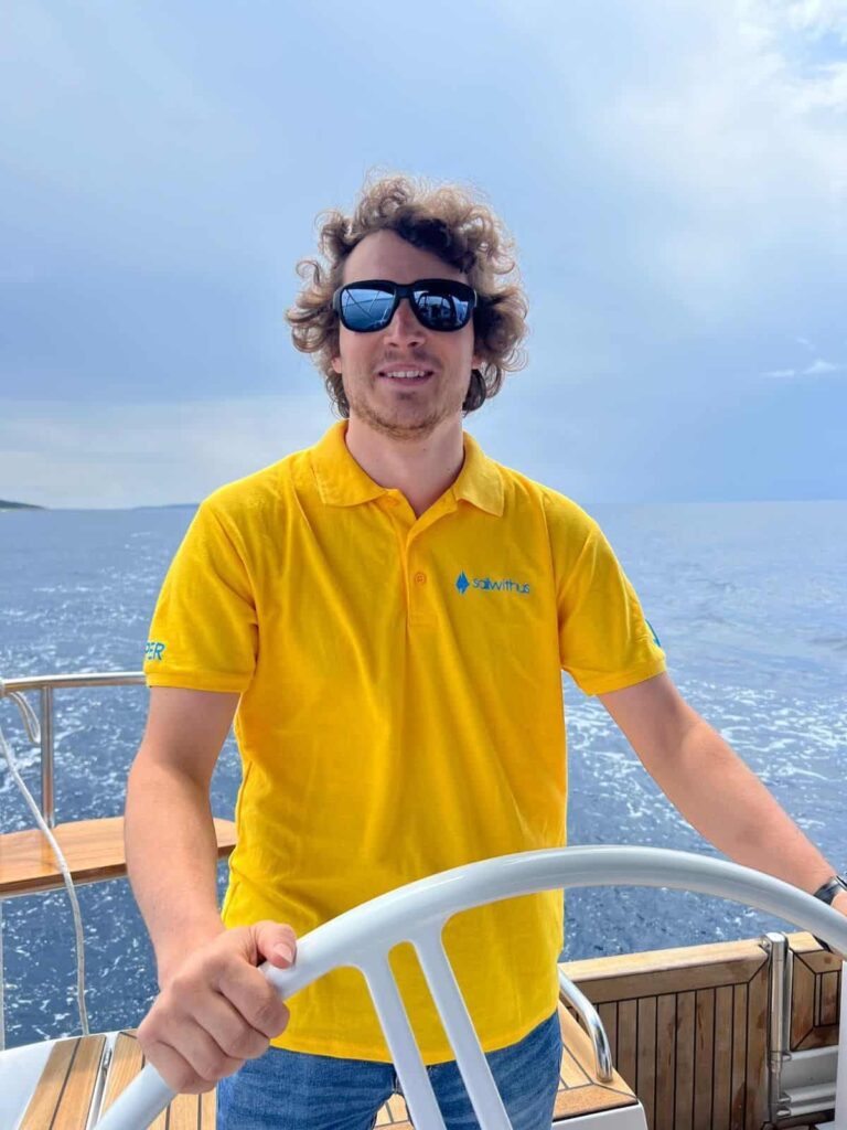 Skipper Julian steuert ein Segelboot im Sailwithus-T-Shirt