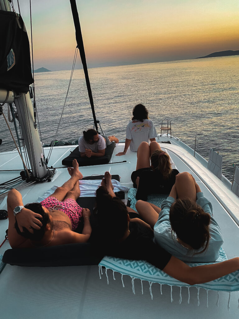 A family enjoying the sunset together on a sailing catamaran