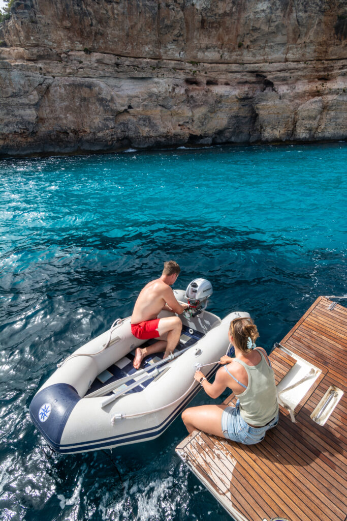 Crew relaxing on a sailing yacht anchored in a Mallorca cove