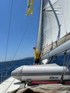 Skipper Matthias steuert ein Segelboot im Sailwithus-T-Shirt