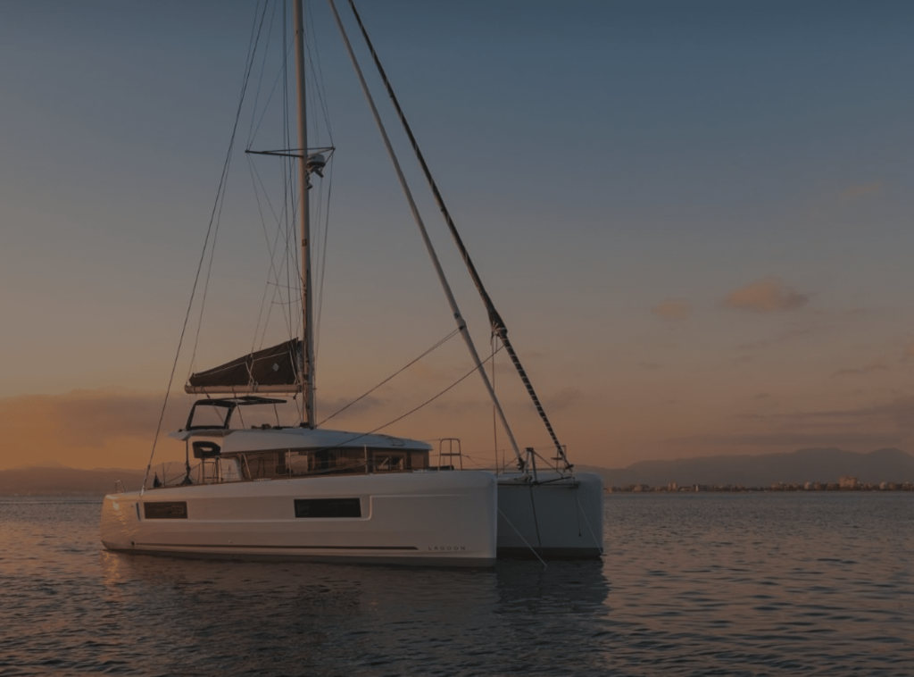 Sailors relaxing on a catamaran at sunset during a shared trip