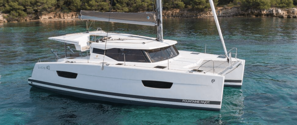A white Fountaine Pajot catamaran sailing at speed on blue water