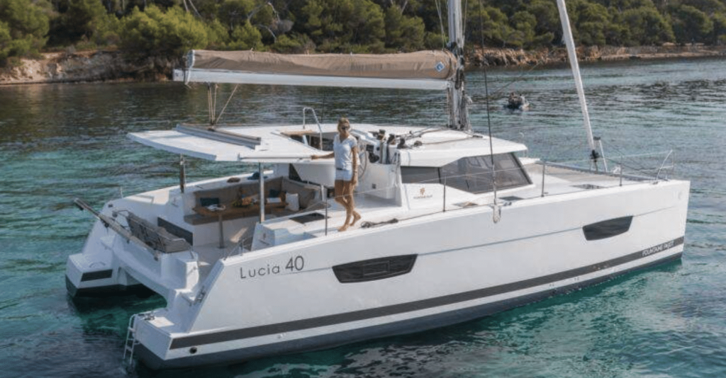 A white Fountaine Pajot catamaran sailing on calm blue water