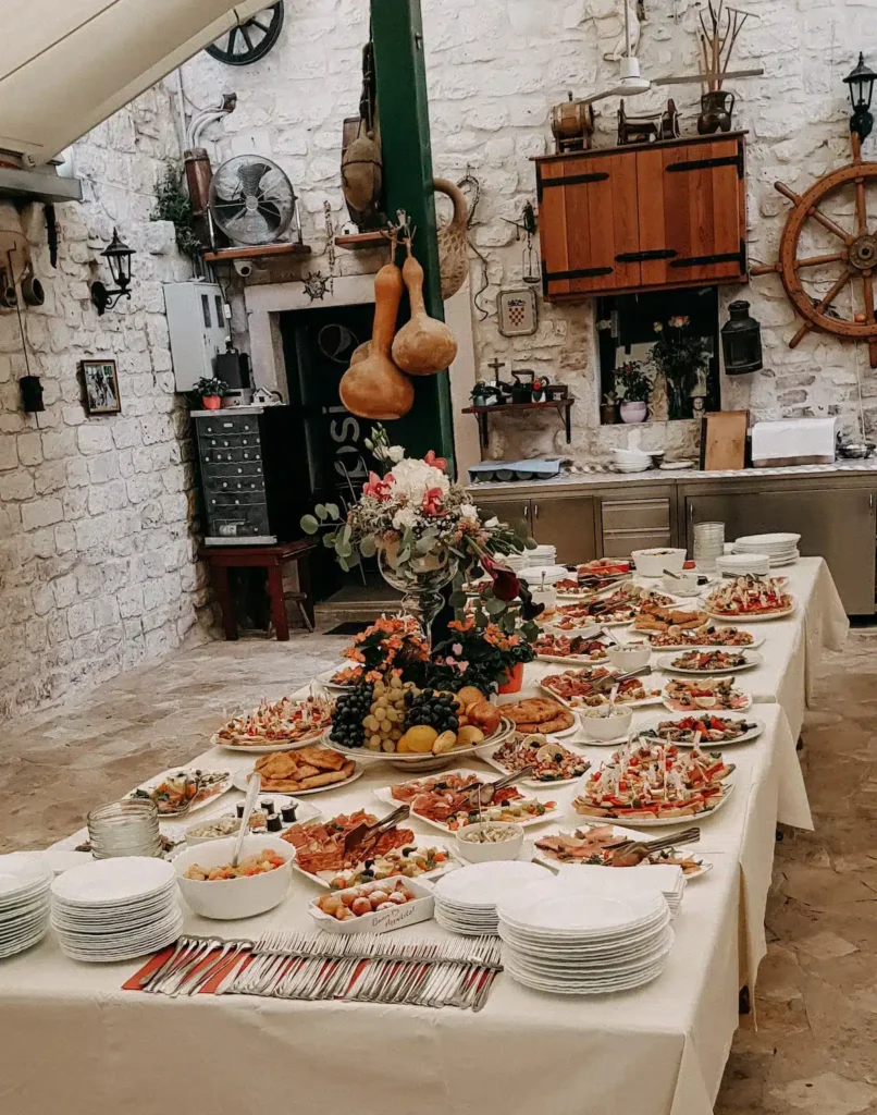 Reichhaltiges Buffet mit einer Auswahl an mediterranen Speisen in einem rustikalen Restaurant mit traditioneller Dekoration.